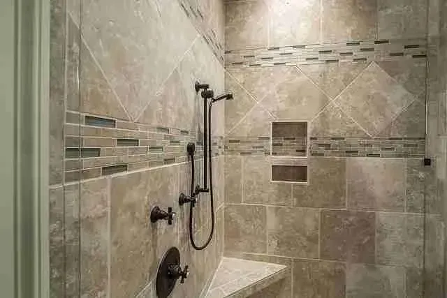 Tiled walk-in shower with travertine tile, a built-in bench and bronze fixtures