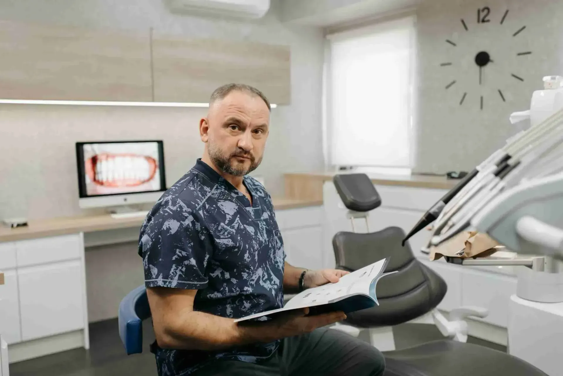 Healthcare worker in scrubs seated in a medical office waiting area
