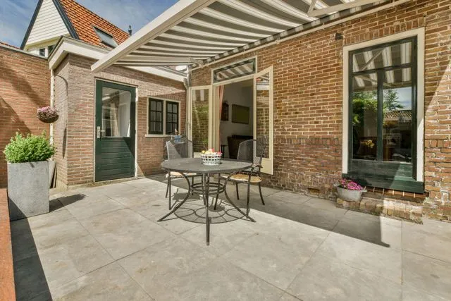 Brick patio with a pergola canopy, dining table and chairs