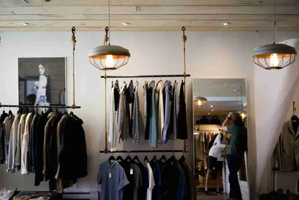 Remodeled boutique retail interior with pendant lighting and clothing displays