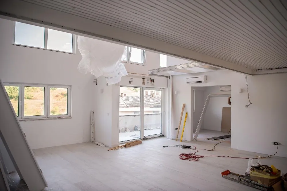 Freshly painted interior mid-renovation with floor protection and a new mini-split